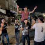 Palestinians celebrate on a street following the news that Israel