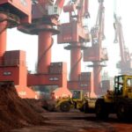 FILE PHOTO: Workers transport soil containing rare earth elements for