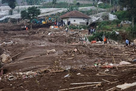 Locals stand in an area affected by landslides following heavy