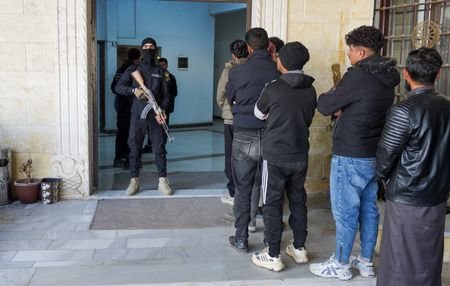 Members of the Kurdish-led Syrian Democratic Forces (SDF) queue to