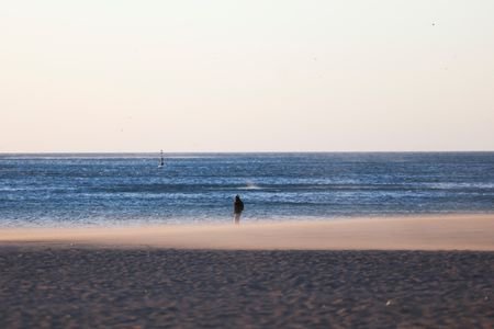 A woman walks on the Barceloneta beach during high winds