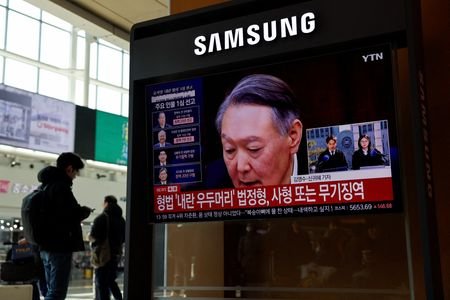 People watch a news report on the sentencing trial of