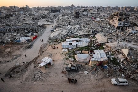 Palestinians gather near the rubble of destroyed residential buildings on