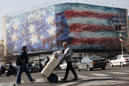 People walk past an anti-U.S. billboard in Tehran