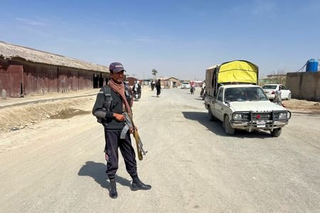 A police officer stands guard along a road leading to