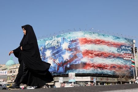 An Iranian woman walks past an anti-U.S. billboard in Tehran