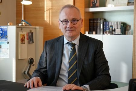 Robert in den Bosch sits at a desk in his