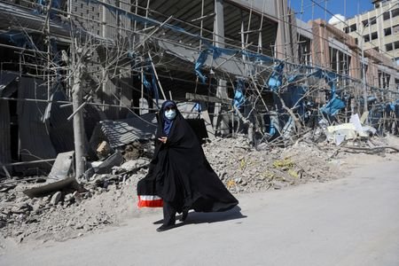 A woman walks on the street amid the U.S.-Israeli conflict