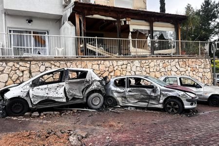 Damaged vehicles and buildings after projectile was launched towards Israel