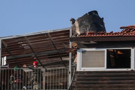 People gather at the site where part of an Iranian