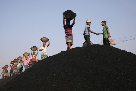 Coal workers are seen at a market as they unload