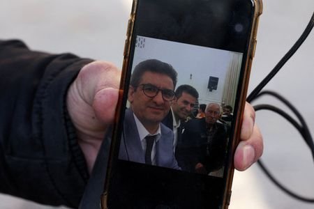 Hamid Mirzahosseini shows a picture of his missing brother, Mahdi