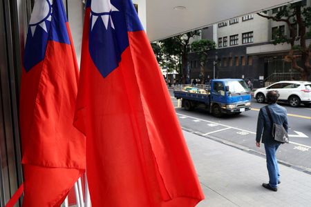 FILE PHOTO: A man walks past Taiwanese flags on a