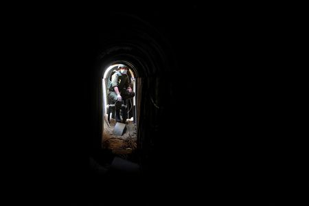An Israeli soldier sits inside a tunnel underneath the European