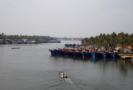 Fishermen travel in a boat in the tributary waters of