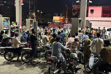 People on their vehicles wait for their turn to get