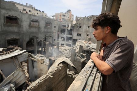 Palestinians inspect the site of a Friday Israeli air strike
