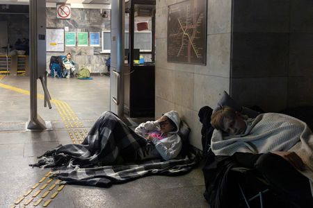 People shelter in a metro station during a Russian drone