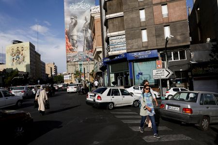 FILE PHOTO: People walk past a billboard about the Strait