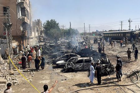 People and police officers gather after a blast near a