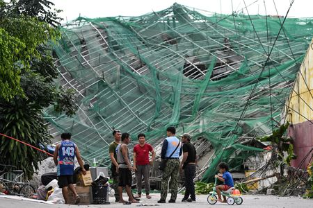 Rescue workers search for trapped survivors among the debris of