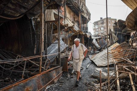 Residents wander around a site of a Russian attack in