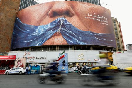 FILE PHOTO: People drive past an anti-U.S. billboard depicting U.S.