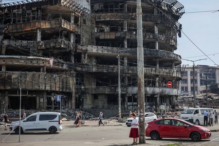 Residents wander around a site of a Russian attack in