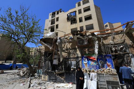 A woman stands next to debris lying in front of