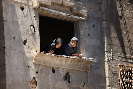 Palestinians inspect the site of an Israeli strike on a