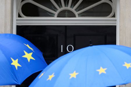People shielding themselves from the rain with EU-themed umbrellas arrive