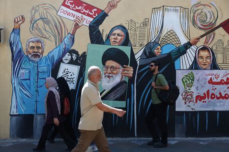 People walk on a street near a mural featuring an
