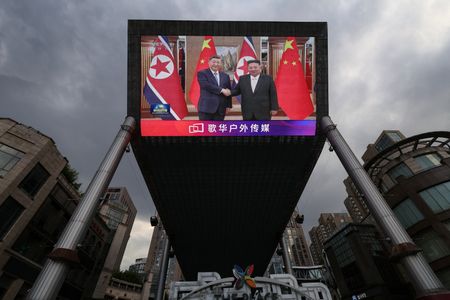 Giant screen at a shopping area in Beijing shows news