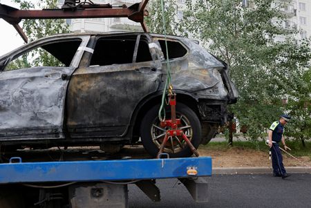 Investigators work at the scene of a car explosion in