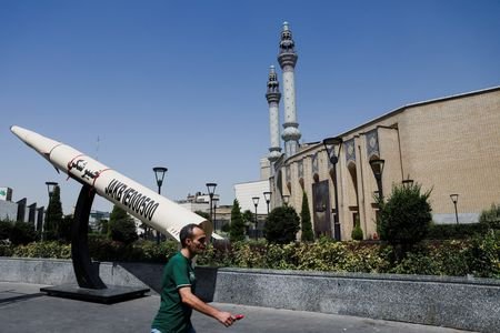 A man walks next to a symbolic mock-up of an