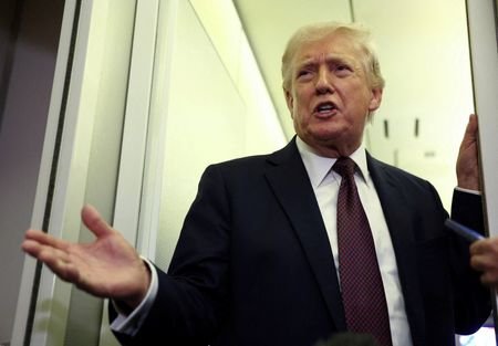 FILE PHOTO: Trump speaks to reporters aboard Air Force One
