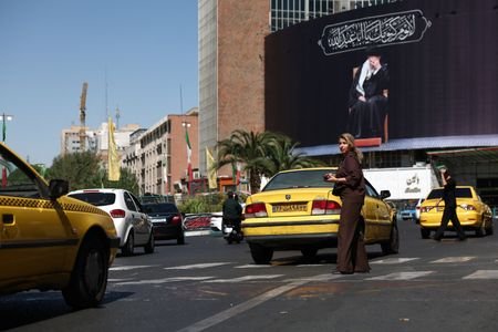 A woman walks past a billboard with a picture of