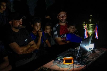 Former Palestinian soccer player Fadi Al-Arawi watches a 2026 World