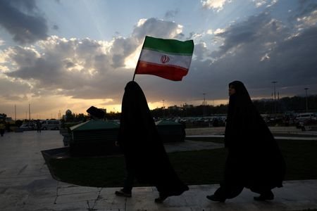 An Iranian woman holds Iran's flag during a rally in