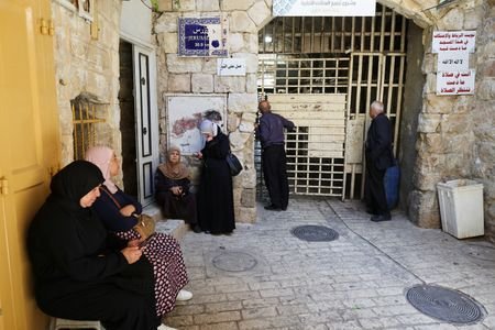 Palestinians wait to enter the Ibrahimi Mosque in the old