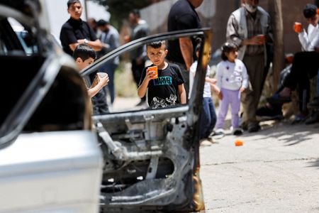 FILE PHOTO: People gather near a damaged car, which Palestinians