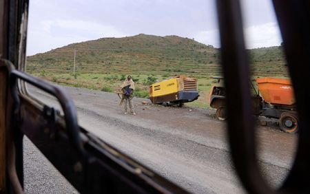 A Tigrayan Militia member stands next to destroyed construction machinery