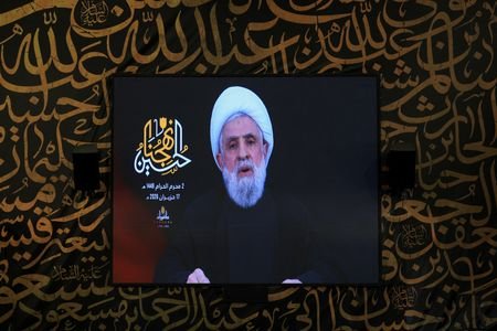 Hezbollah chief Naim Qassem delivers a televised speech on a