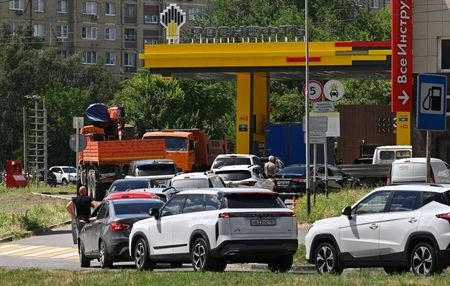 FILE PHOTO: Cars queue to refuel at a petrol station
