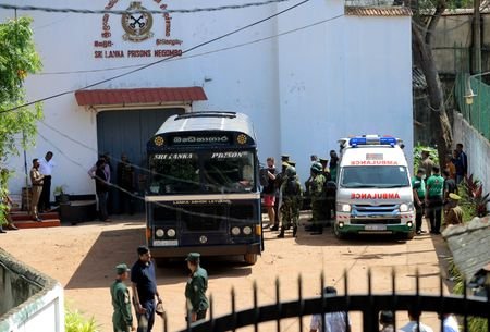 Prisoners board a bus to be transferred following clashes at