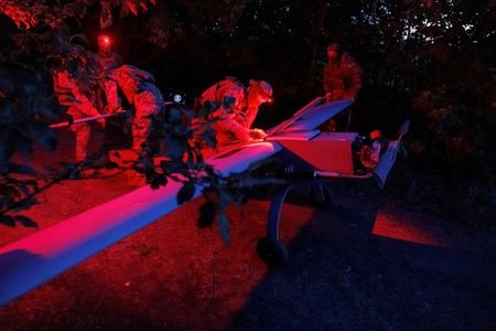 Ukrainian service members prepare a Zozulia mid-strike drone for a