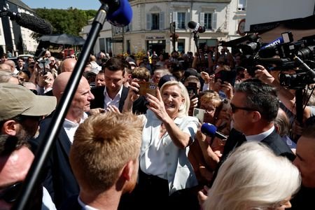 French far-right leaders Le Pen and Bardella visit a market