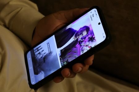 A mobile phone showing a picture of Faisal Jatoi, who