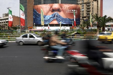 People drive past anti-U.S. billboard depicting U.S. President Donald Trump