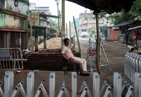 A police officer sits as he guards a street following